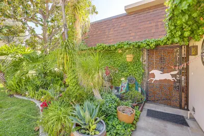a garden with plants and a gate with a horse on it at Redlands Home with Community Perks 1 Mi to Downtown in Redlands