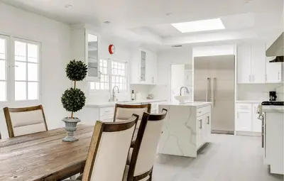 a kitchen with white cabinets and a table and chairs at Monthier Melrose PO7H2O0 in Los Angeles