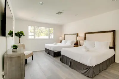 a hotel room with two beds and a chair at Monthier Melrose PO7H2O0 in Los Angeles