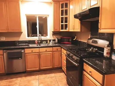 a kitchen with wooden cabinets and a stove top oven at House Downtown OC Santa Ana in Santa Ana