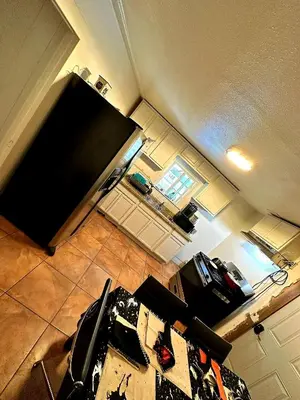 an aerial view of a kitchen with a large black refrigerator at House Downtown OC Santa Ana in Santa Ana