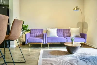 a purple couch in a living room with a table at Los Angeles Modern Studio in Los Angeles