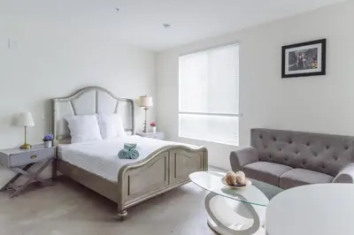 a white bedroom with a bed and a couch at Suite Little Tokyo Los Angeles in Los Angeles