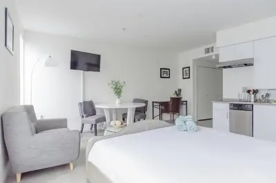 a white room with a bed and a table and chairs at Suite Little Tokyo Los Angeles in Los Angeles