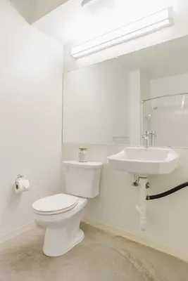 a white bathroom with a toilet and a sink at Suite Little Tokyo Los Angeles in Los Angeles