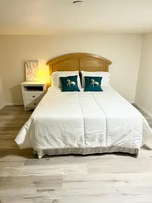 a bedroom with a large white bed with blue pillows at Brand-New Dtla building with rooftop patio in Alhambra