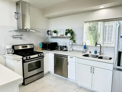 a white kitchen with a stove and a sink at Brand-New Dtla building with rooftop patio in Alhambra
