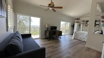 a living room with a couch and a ceiling fan at Panorama Tropical Resort & Spa with Sunset City View in Santa Ana