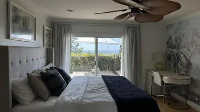 a bedroom with a bed with a ceiling fan and a window at Panorama Tropical Resort & Spa with Sunset City View in Santa Ana