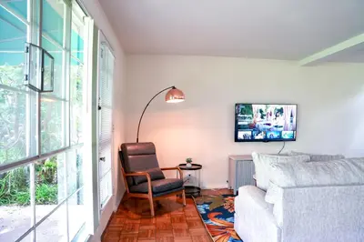 a living room with a couch and a chair and a tv at Los Angeles Miracle Mile Spacious 2BR Townhouse in Los Angeles