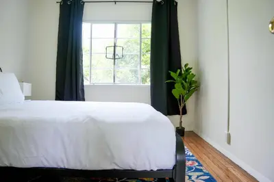 a bedroom with a white bed and a window at Los Angeles Miracle Mile Spacious 2BR Townhouse in Los Angeles
