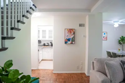 a living room with white walls and a staircase at Los Angeles Miracle Mile Spacious 2BR Townhouse in Los Angeles