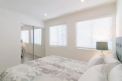 a white bedroom with a bed and a mirror at Sunny 1 Bedroom in the Heart of Venice Beach - 2 in Los Angeles