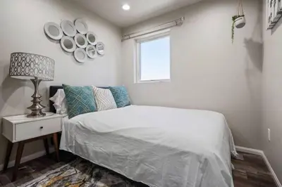 a bedroom with a bed with a lamp and a window at Spacious family Guesthouse private entry near six flags in Santa Clarita
