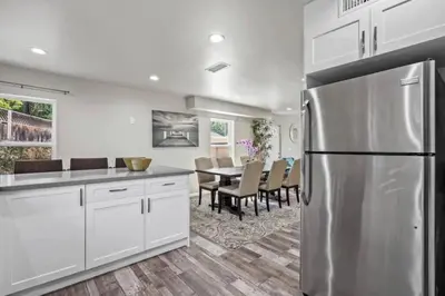 a kitchen with a stainless steel refrigerator and a table at Spacious family Guesthouse private entry near six flags in Santa Clarita