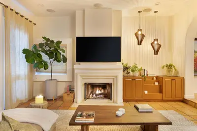 a living room with a fireplace and a flat screen tv at The Canal Escape - canal-front Italian villa in Los Angeles