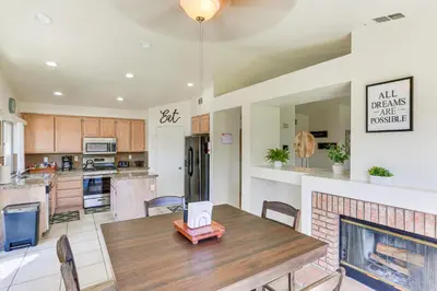 a kitchen and dining room with a table and a fireplace at Victorville Home with Large Yard and Charcoal Grill! in Victorville