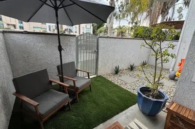 a patio with two chairs and an umbrella at Carpinteria Beach Studio Condo in Carpinteria