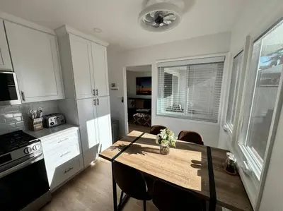 a kitchen with a wooden table with chairs in it at Carpinteria Beach Studio Condo in Carpinteria