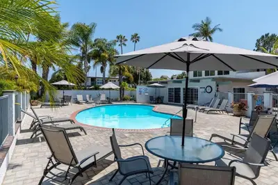 a table with an umbrella next to a swimming pool at Carpinteria Beach Studio Condo in Carpinteria