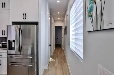 a kitchen with a stainless steel refrigerator and white cabinets at H&H New Built 2023 Hidden Gem Heart of OC 3 Queen Beds in Westminster