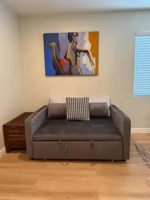 a couch in a living room with a painting on the wall at Pasadena Old Town village in Pasadena