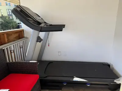 a treadmill in a room with a red bench at Pasadena Old Town village in Pasadena