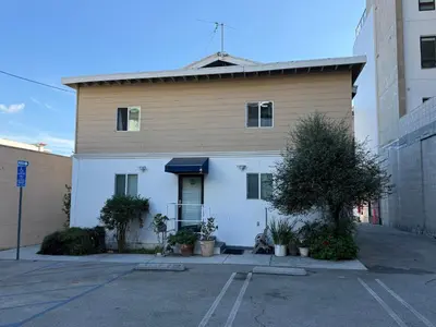 a building with a dog sitting in a parking lot at Pasadena Old Town village in Pasadena