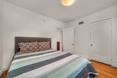 a bedroom with a bed in a white room at Chic Charming 2-Bedroom with office in the WeHo in Los Angeles