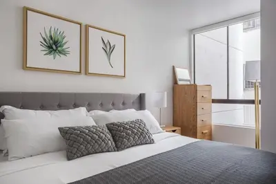 a bedroom with a bed with two pictures on the wall at Blueground Hollywood gym near Walk of Fame LAX-1217 in Los Angeles
