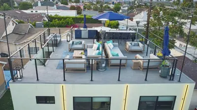a deck on a boat with chairs and an umbrella at Corner Haus Los Angeles in Los Angeles
