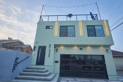 a white building with a garage in front of it at Corner Haus Los Angeles in Los Angeles