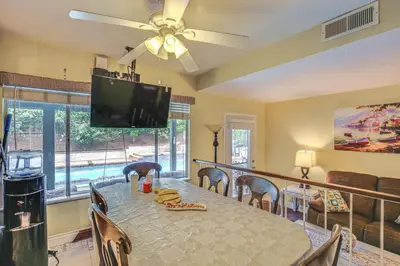 a dining room with a table and a flat screen tv at Anaheim Home with Pool, 14 Mi to Disneyland! in Anaheim