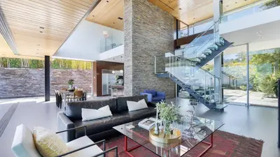 a living room with a glass table and a staircase at Hollywood Overlook by AvantStay Private Pool Hot Tub Panoramic Views in Los Angeles