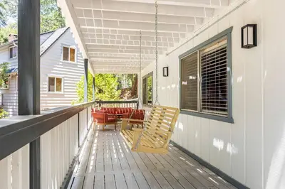 a porch with two chairs and a table on a house at Family Lake Arrowhead Home Sleeps 12 and Gameroom in Lake Arrowhead