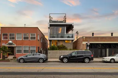 three cars parked in a parking lot in front of a building at Venice Rooftop 5bd 4 bt steps from the beach in Los Angeles