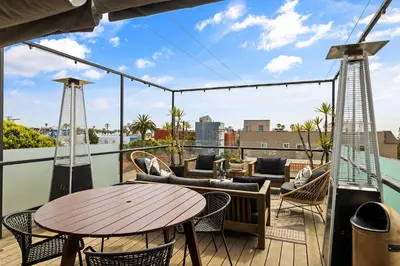a patio with a table and chairs on a balcony at Venice Rooftop 5bd 4 bt steps from the beach in Los Angeles