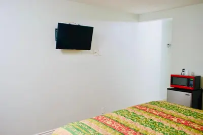 a bedroom with a bed with a tv on the wall at Red Carpet Motel By Ontario in Ontario