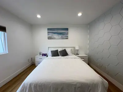 a bedroom with a large white bed with two pillows at Modern comfort private room 1 in Los Angeles
