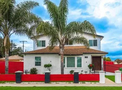 a house with a red fence and palm trees at Stylish Retreat Private Room 2 in Los Angeles