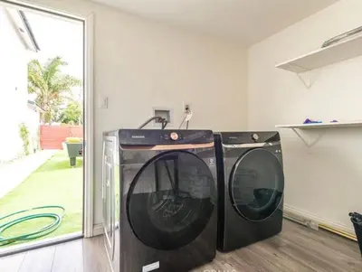 two washing machines sitting in a laundry room at Cozy Haven private room 3 in Los Angeles
