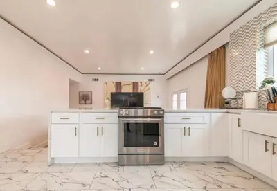 a kitchen with white cabinets and a stove at Charming Private Room 4 in Los Angeles