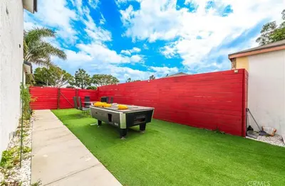 a backyard with a red fence and a grill at Charming Private Room 4 in Los Angeles