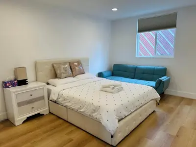 a bedroom with a bed and a blue couch at Chic and Secure Private room in modern home 6 in Los Angeles