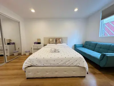 a bedroom with a bed and a blue couch at Chic and Secure Private room in modern home 6 in Los Angeles