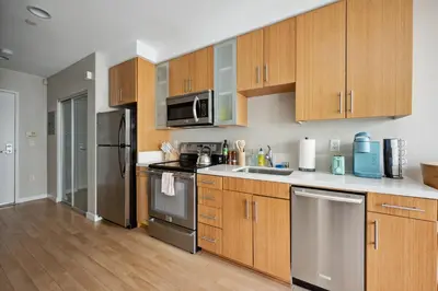 a kitchen with wooden cabinets and stainless steel appliances at Comfy studio near SM Promenade! Free parking! in Los Angeles