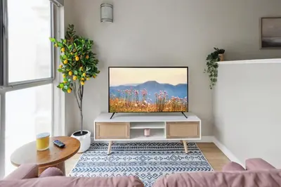 a living room with a flat screen tv on a stand at Comfy studio near SM Promenade! Free parking! in Los Angeles