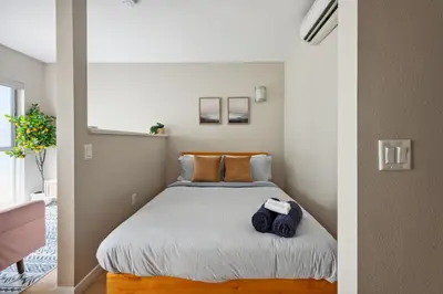 a small bedroom with a bed with blue towels on it at Comfy studio near SM Promenade! Free parking! in Los Angeles