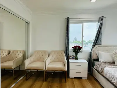 a bedroom with two chairs and a bed and a window at Contemporary Private Room 7 in Los Angeles
