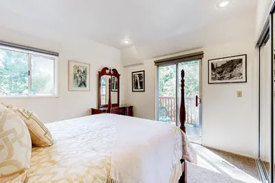 a bedroom with a large white bed and windows at Natures Reserve in Lake Arrowhead